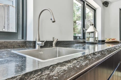 Kitchen counter with a dark stone-look resurfaced finish and undermount sink